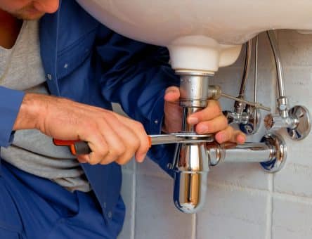 plumber fixing sink pipe