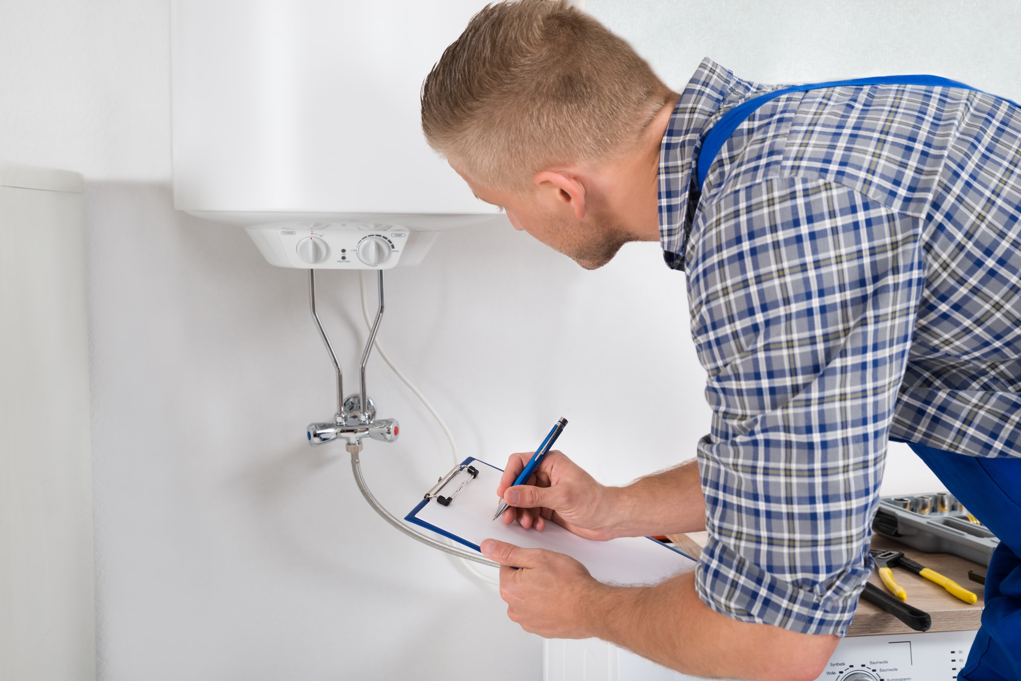 Technician servicing heating boiler - Tom's Plumbing and Drain Service, LLC