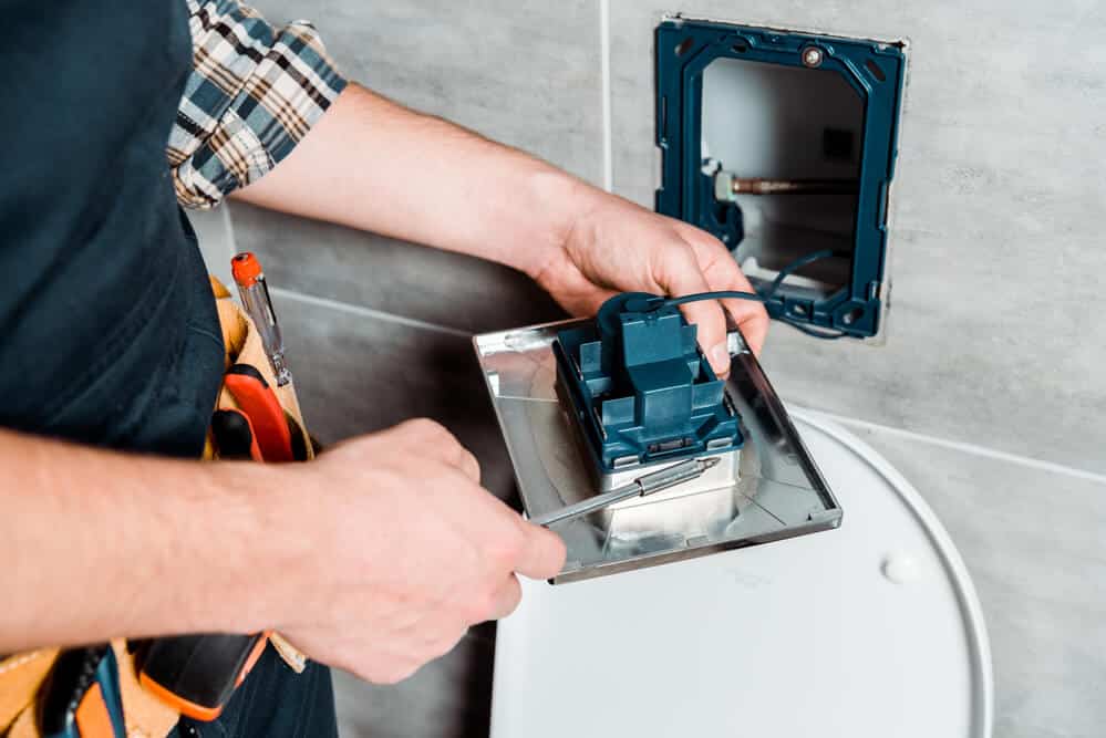 Workman holding screwdriver - Tom’s Plumbing