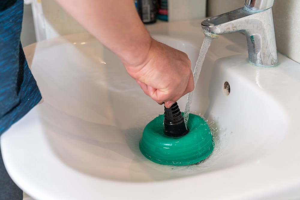 male hands clean the blockage in the washbasin